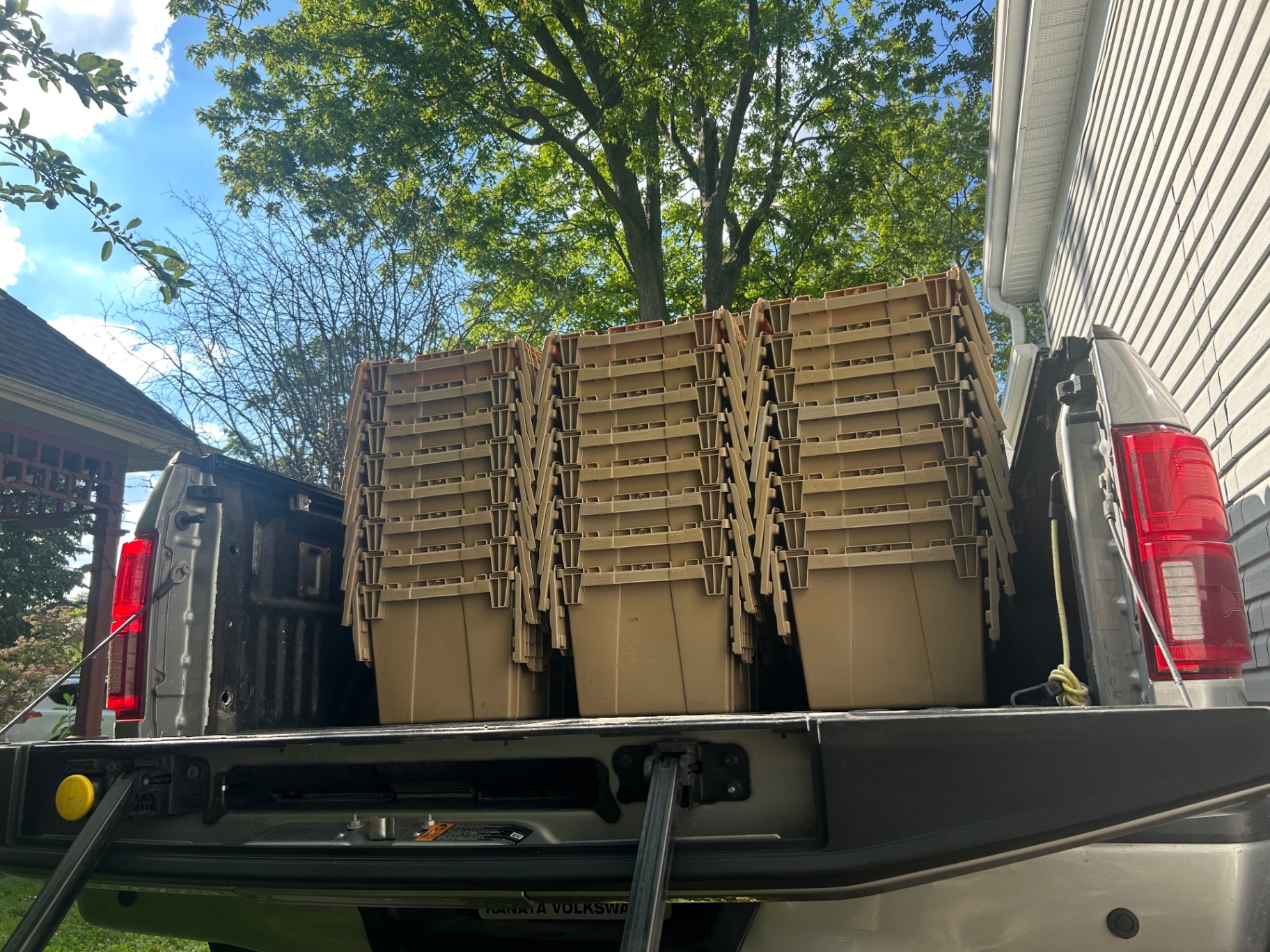 Empty nested bins stacked in a truck bed ready for pickup